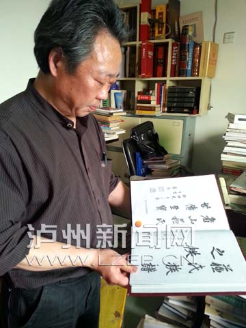 苏佐向记者展示新修订的《苏氏族谱》